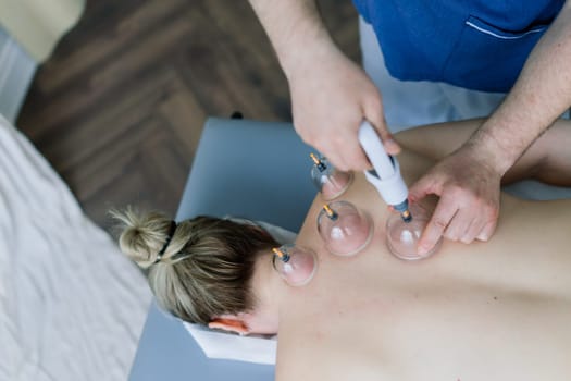 A woman does a hip massage with vacuum jar for an anti-cellulite massage.