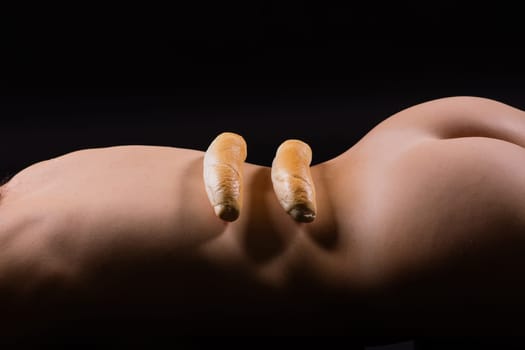 Female sensual body holding one big a white bread bun with sesame seeds, horizontal picture