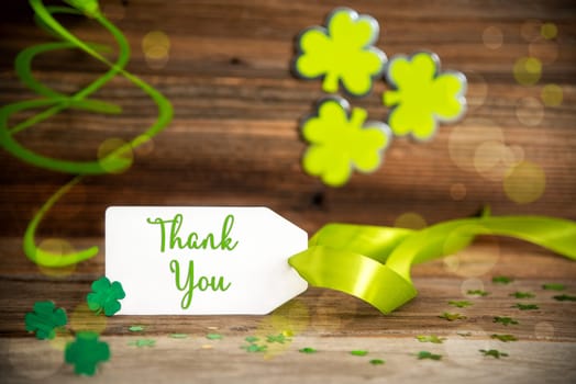 White Label With Text Thank You. Saint Patrick's Day Decoration With Green Shamrock And Clover. Wooden Vintage Background With Festive Ribbon.