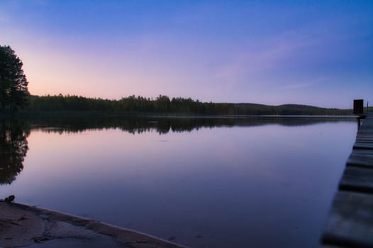 Sunset on a lake in Sweden. Blue hour on calm water. Nature photo from Scandinavia. Landscape shot