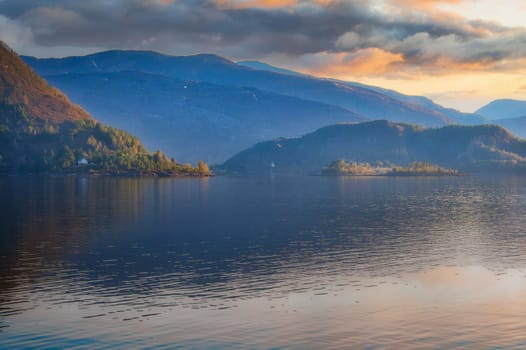Fjord in Norway at Westcap. Sunset over the water. Mountains in the background. Landscape shot from Scandinavia