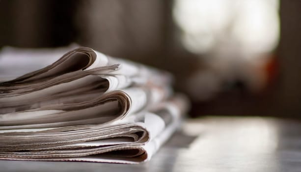 Stack of newspapers on the table in the morning light. Selective focus. Media news concept. AI generated