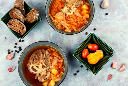 Soup with meat on old rustic wooden table. Traditional Ukrainian borscht. Food recipe.