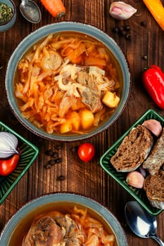 Soup with meat on old rustic wooden table. Traditional Ukrainian borscht. Food recipe.