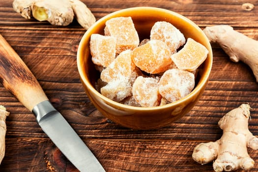 Heap of sweat candied ginger on wooden kitchen table.. Candied ginger cubes. Healthy sweets.