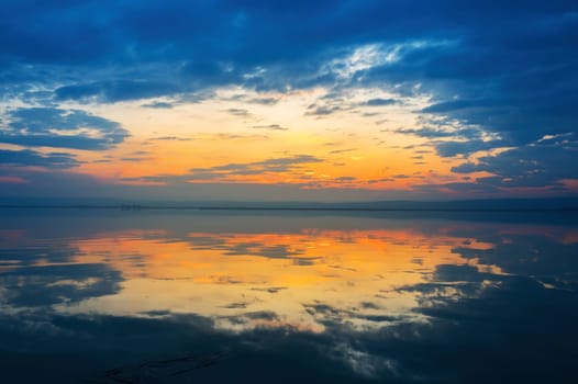 reflections of clouds at sunset in a lake