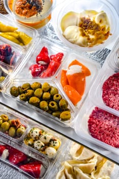 A display of variety of prepackaged food products in plastic boxes.