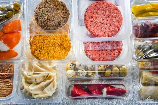 A display of variety of prepackaged food products in plastic boxes.