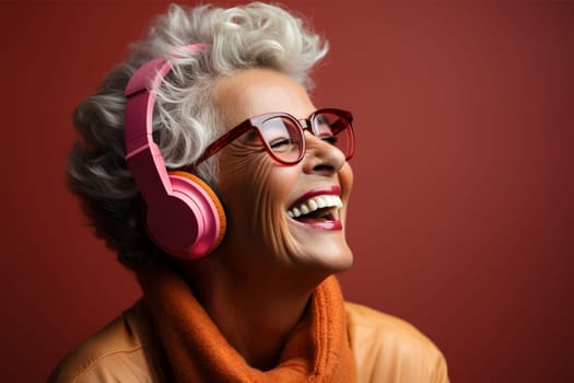 An elderly woman with glasses with gray hair experiences pure joy while listening to music through pink headphones against a bright background.