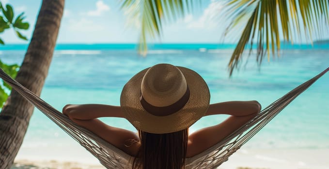 woman wearing hat relaxing in a hammock at the beach in a tropical luxury resort from behind, dappled sunlight, turquoise sea
