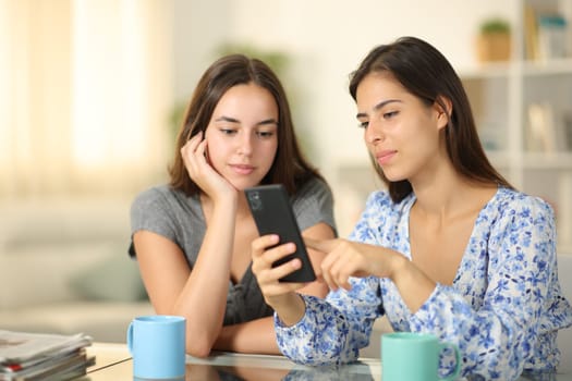 Serious friends checking phone content at home