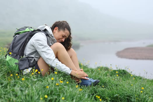 Single hiker suffering ankle ache after strumbling in nature