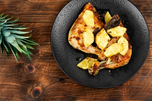 Roasted quarters chicken legs with pineapple slices. Baked chicken meat. Close up.