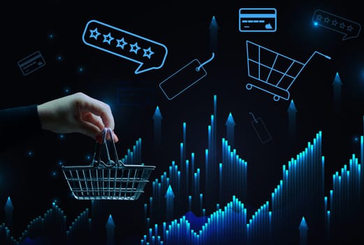 A woman's hand holds a metallic shopping cart and payment card icons, the concept of starting a sale, high income in retail business