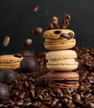 Stack of multi-colored macarons on a background of coffee beans, black background