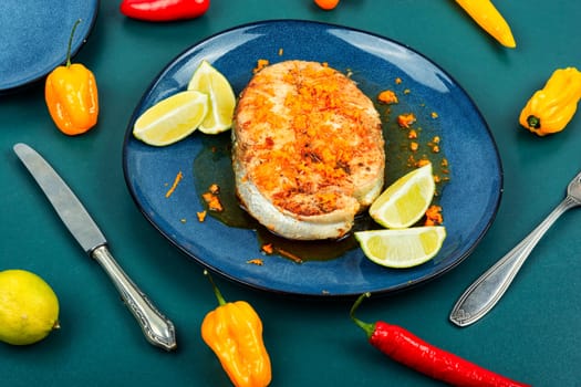Plate of grilled trout steak with orange sauce. Healthy food with omega.