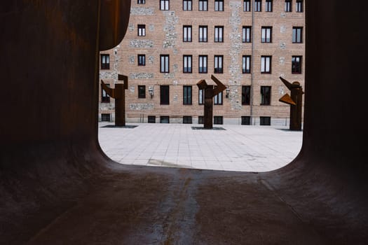 View of the Plaza del Rollo in Madrid, Spain through the sculpture symbolising the Puerta de la Libertad (Gate of Frredom), a memorial dedicated to the Madrilenians deported to Mauthausen. Visible are the three columns called Los Árboles de los Sueños (The Trees of Dreams) that complete the work of sculptor José Miguel Utande.