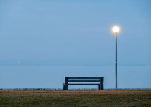 evening on the lake with bench and lantern