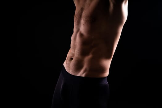 Handsome bodybuldier man posing showing muscle, shirtless torso showing pectorals and sixpacks