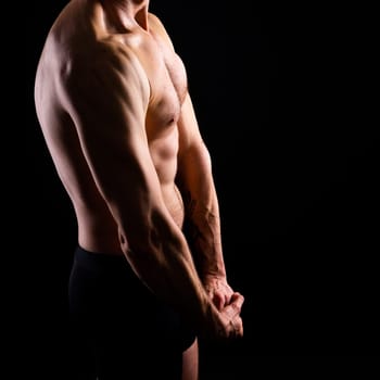 Handsome bodybuldier man posing showing muscle, shirtless torso showing pectorals and sixpacks