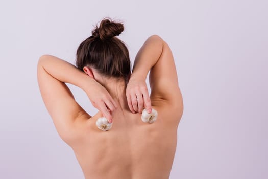 Young nude woman with garlic, a naked body