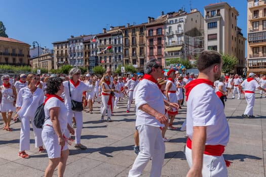 Pamplona, Spain: 09 July 2023: People celebrate San Fermin festival in traditional white abd red clothing with red necktie, Pamplona, Navarra, Spain.