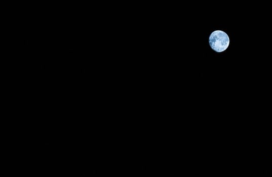 The round moon is blue with spots on a black background in the upper right corner.