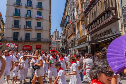 Pamplona, Spain: 09 July 2023: People celebrate San Fermin festival in traditional white abd red clothing with red necktie, Pamplona, Navarra, Spain.