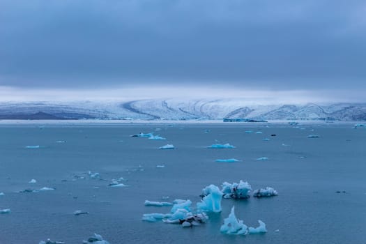Beautiful blue icebergs reflected in the Jokulsarlon glacial lagoon. Southern Iceland. Part of the Vatnajokull National Park and Vatnajokull glacier, the largest glacier in Europe.