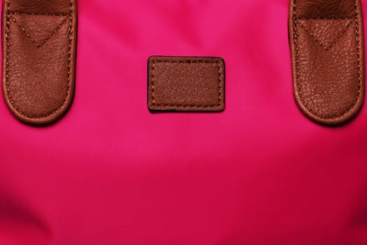 Part of a red female handbag with brown leather handles as background texture. Copy space.