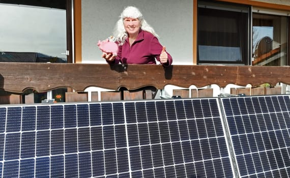 A woman is pleased that she is saving money with a balcony power plant