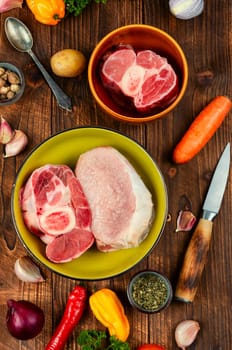 Juicy raw piece meat and vegetables on the kitchen table. Set of ingredients for soup or borscht.