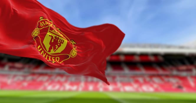 Manchester, UK, Oct. 2 2023: Close-up of Manchester United Football Club flag waving at Old Trafford stadium. Premier League pro team. Illustrative editorial 3d illustration render. Selective focus