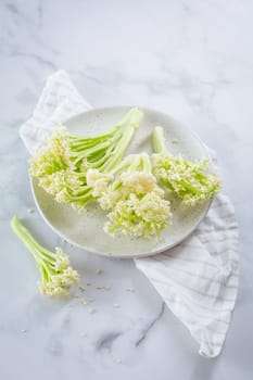 Raw organic baby stick cauliflower in a bowl.