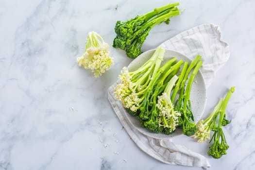 Fresh raw green bimi, broccolini and baby stick cauliflower in a bowl