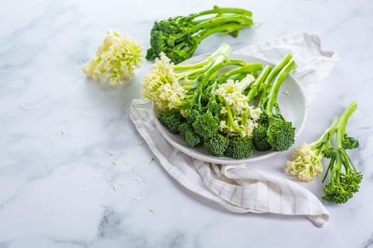 Fresh raw green bimi, broccolini and baby stick cauliflower in a bowl