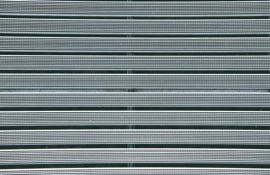 Metal grille with a textured rubber coating in gray color close-up view from above.Texture or background