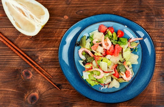 Pomelo salad with shrimp, tomatoes and lettuce on a plate.