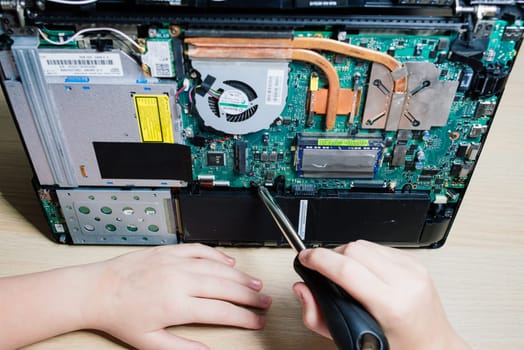 Service engineer install new chips to laptop. Repairing and upgrading laptop concept. Close up.