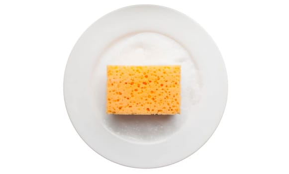 Cleaning yellow sponge on a white plate with soap foam isolated on a white background. Using a scrub sponge to scrub and wash food stains and dirt on white dishes after meals. Cleaning concept