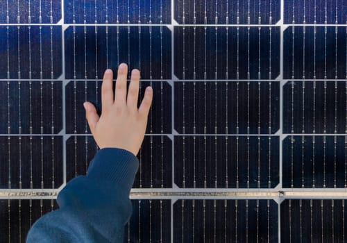 Child boy touching solar panel surface. Environmental education on renewable energies