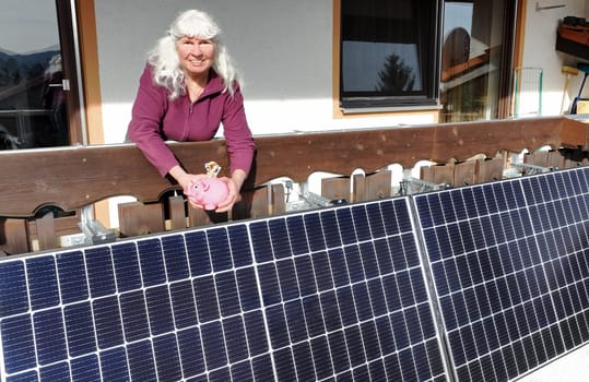 A woman is pleased that she is saving money on electricity with a balcony power station