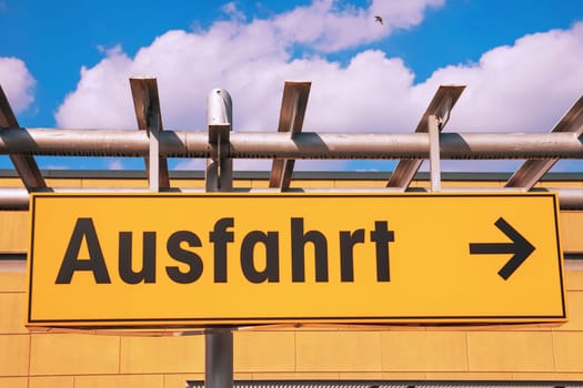 German road sign. Exit sign with an arrow pointing to the right in a supermarket. A yellow sign with the German word Ausfahrt.