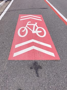 Painting in red and white, symbol for a cycle lane exclusively for bicycles, in an urban center next to the avenue.