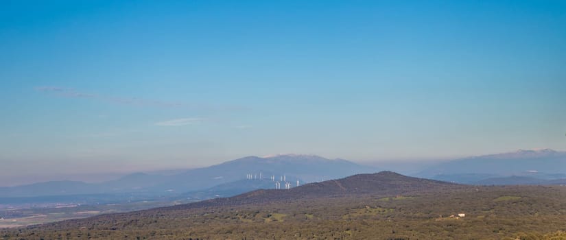 Wind turbines seen from Palancar Convent, Pedroso de Acim, Caceres, Spain. Industrialization of the countryside concept