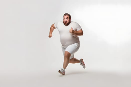 Overweight young adult Caucasian man running on white background, concept of overweight and weight loss. Neural network generated image. Not based on any actual person or scene.