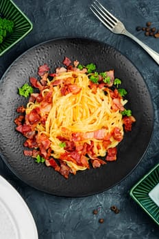 Pasta with carbonara sauce, bacon, parmesan and eggs. Top view.
