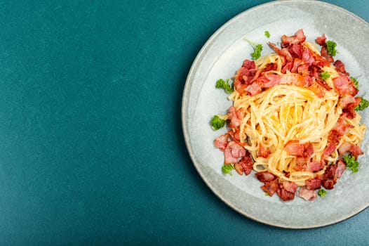 Pasta with carbonara sauce, bacon, parmesan and eggs. Top view.