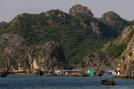 Cat Ba, Vietnam - November 29th, 2016: Houses of a floating village nearby Cat Ba Island in the famous Halong Bay in Vietnam shines brightly in the sun.