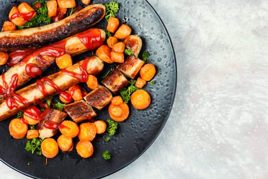 Grilled turkey sausages with roasted carrots on the plate. Copy space.